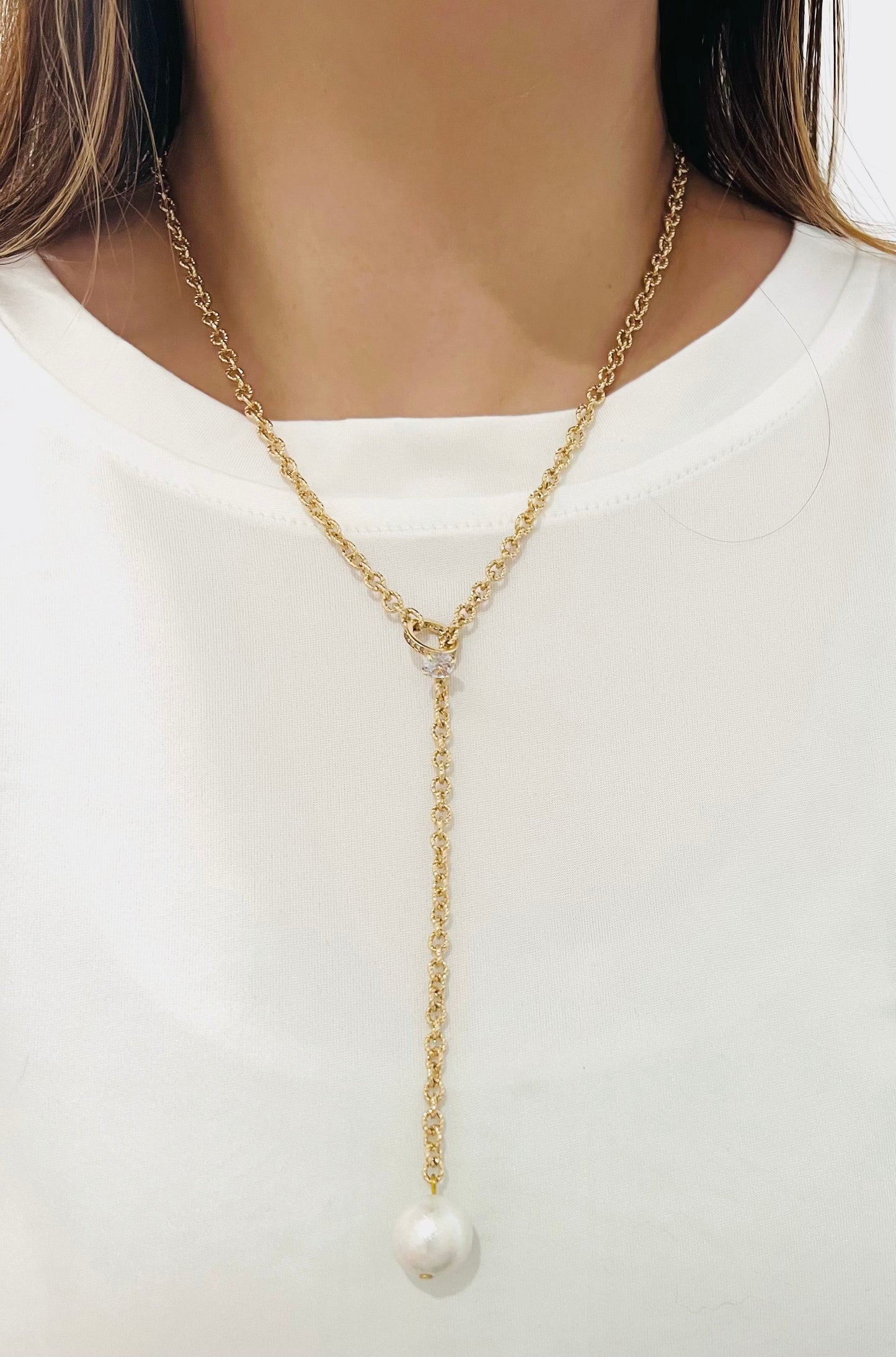 Glittering golden necklace with hanging pearl