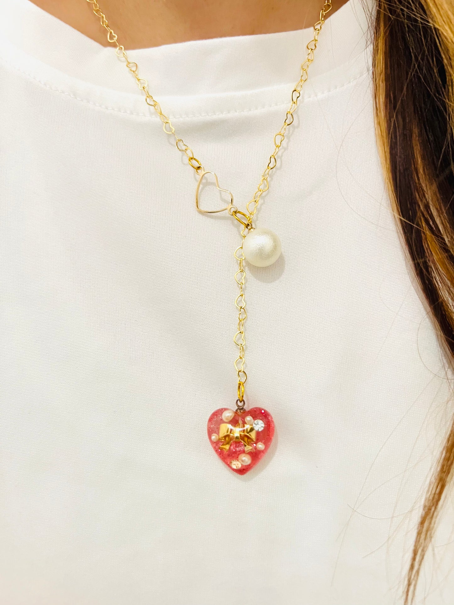 Heart-shaped gold necklace with hanging red heart