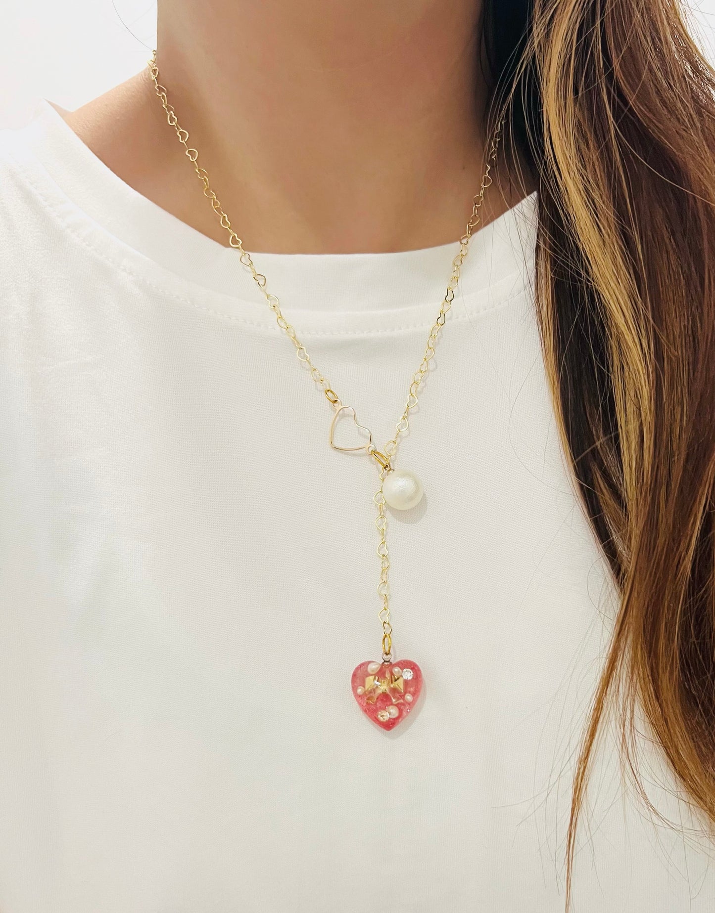 Heart-shaped gold necklace with hanging red heart